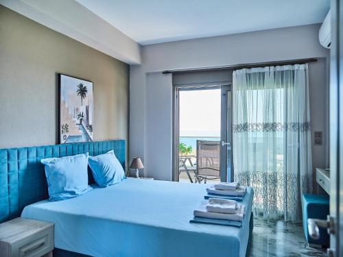 a bedroom with a blue bed with a view of the ocean at Atel Villas in Xanthi