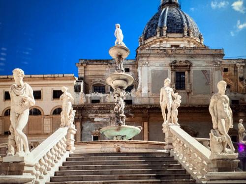 a fountain in front of a building with statues at Daniel's Winter in Palermo