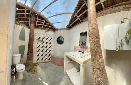 a bathroom with a sink and a toilet and a ceiling at La Sardina in Todos Santos
