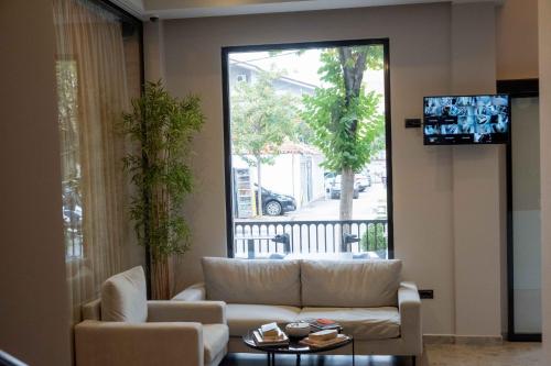 un soggiorno con divano e una grande finestra di Senator Hotel a Tirana
