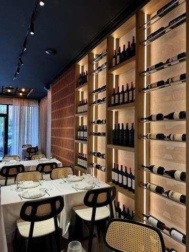 a dining room with tables and wine racks at Senator Hotel in Tirana