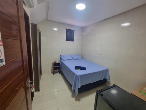 a small room with a blue bed in it at Pousada Ouro Branco in Macau