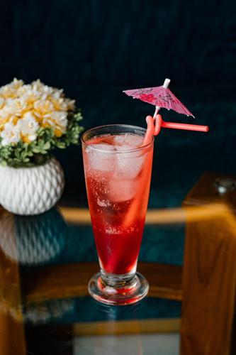 a drink with an umbrella on a table at Royal Raj Hotel in Rājshāhi