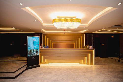a large lobby with a bar with a chandelier at Royal Raj Hotel in Rājshāhi