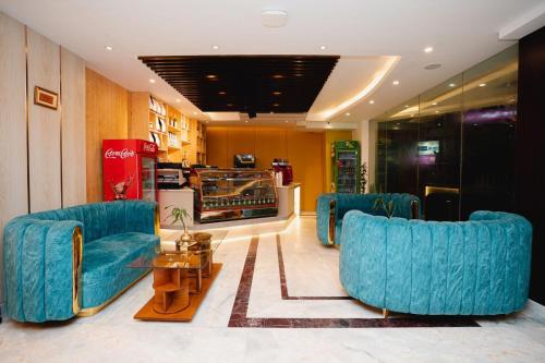a lobby with two blue chairs and a table at Royal Raj Hotel in Rājshāhi