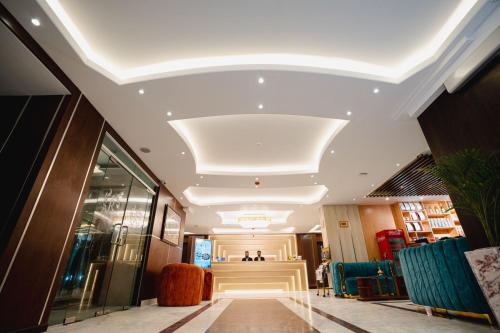 a lobby with a hallway with chairs and a ceiling at Royal Raj Hotel in Rājshāhi