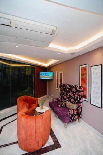 a living room with two chairs and a couch at Royal Raj Hotel in Rājshāhi