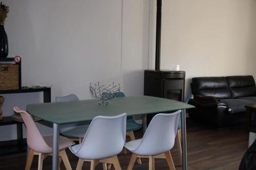 une salle à manger avec une table et des chaises vertes dans l'établissement Maison de 100m2 récemment rénovée Cancale, à Cancale