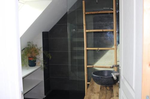 La salle de bains est pourvue d'une étagère en bois et d'un lavabo. dans l'établissement Maison de 100m2 récemment rénovée Cancale, à Cancale