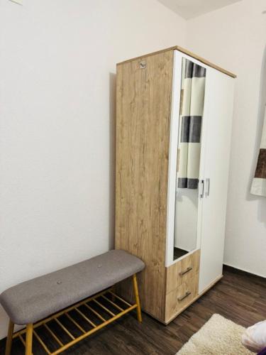 a room with a wooden cabinet and a bench at Apartments Paradise in Ličko Petrovo Selo