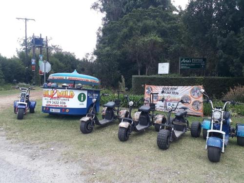 a group of scooters parked next to a bus at Stormsriver Backpackers Dijembe in Stormsrivier