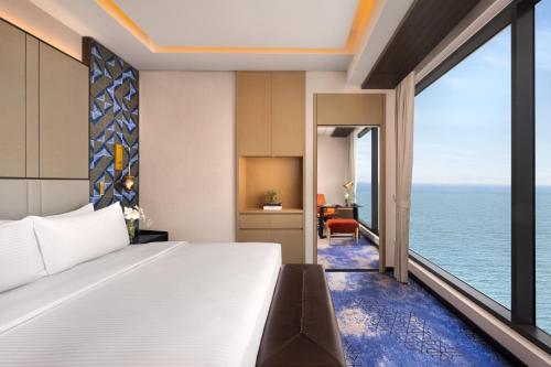 a bedroom with a bed and a view of the ocean at Amari Colombo, Sri Lanka in Colombo