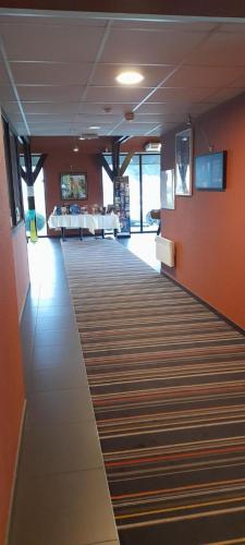a room with a hallway with orange walls and a carpet at ibis Styles Segre in Segré