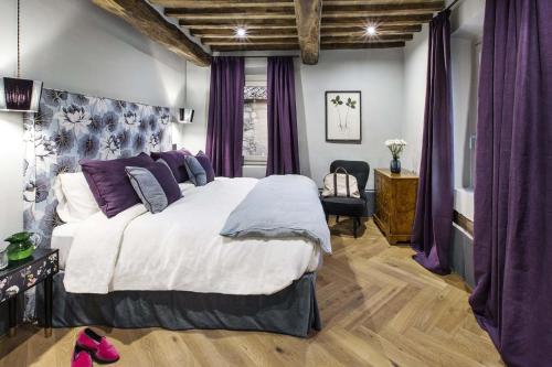 1 dormitorio con 1 cama grande y cortinas moradas en AMORE RENTALS - Villa Viola, en Sarteano
