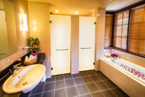 a bathroom with a tub and a sink and a bath tubermottermott at Sebana Cove Resort in Pengerang