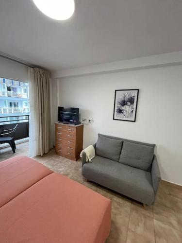 a living room with a bed and a couch at Playa Jardín Bus terminal Pool in Puerto de la Cruz