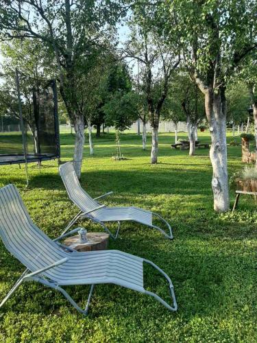 two chairs and a table in a park at Apartments Paradise in Ličko Petrovo Selo