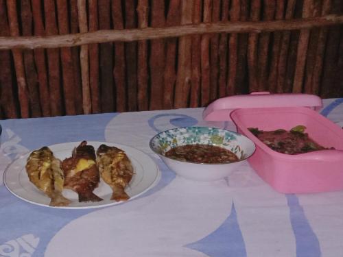 a table with two plates of food and a bowl of food at manyaifun guest house in Minyaifuin