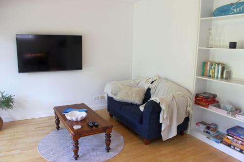 a living room with a blue couch and a coffee table at Seashell Oasis at Cape Woolamai in Cape Woolamai
