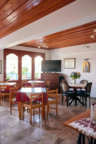 a dining room with tables and chairs andwindows at Vlachakis Hotel in Stalida