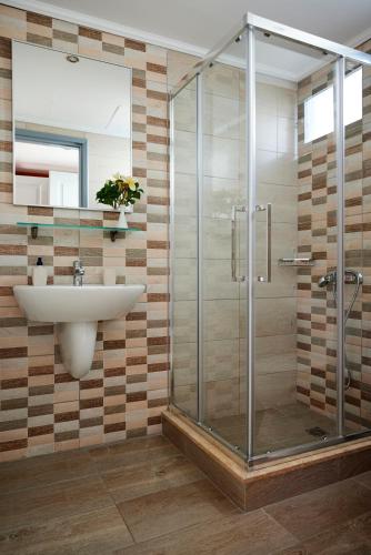 a bathroom with a sink and a glass shower at Vlachakis Hotel in Stalida