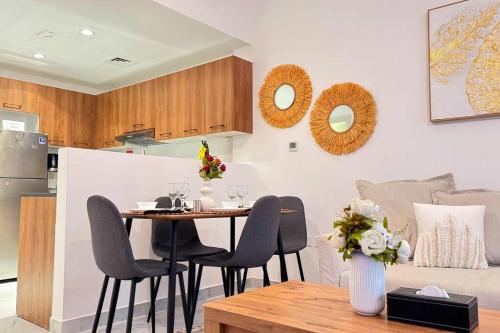 a dining room and kitchen with a table and chairs at Daisy 1BR Oasis - Elegant Urban Escape in Abu Dhabi