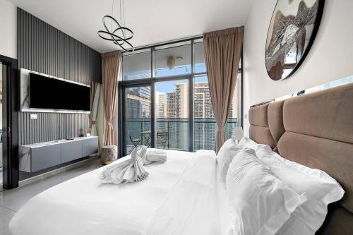 a bedroom with a large white bed with a large window at 1BR Dubai, Merano Canal View Retreat Near Metro Dining Shopping Mall in Dubai