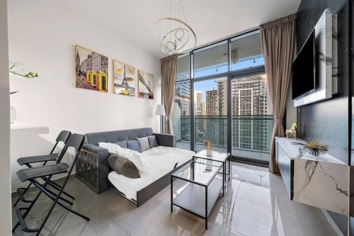 a living room with a couch and a large window at 1BR Dubai, Merano Canal View Retreat Near Metro Dining Shopping Mall in Dubai