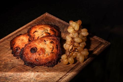 two muffins on a wooden plate with a bunch of grapes at Maison d'hôtes & SPA La Scierie in Salins-les-Bains
