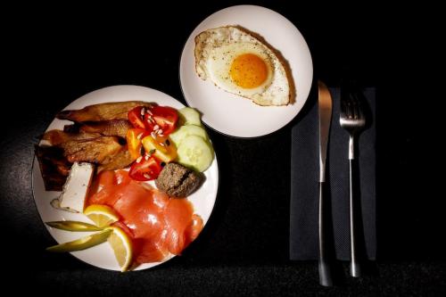 two white plates of food with an egg and meat at Maison d'hôtes & SPA La Scierie in Salins-les-Bains