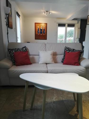 a living room with a couch and a table at Kerguil-léon maison familiale 2 chambres, plages à 10 min en voiture in Moëlan-sur-Mer