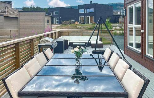 a glass table with a vase of flowers on a balcony at Awesome Home In Vrådal With Lake View in Vradal