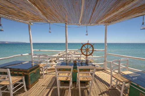 a table and chairs on the beach with the ocean at Residence Borgomare in Albenga