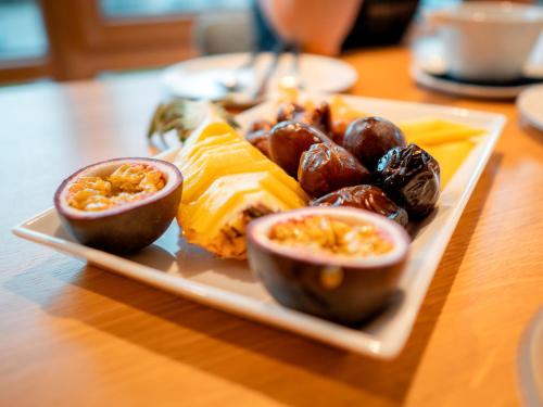a plate of food with eggs and fruit on a table at Maison d'hôtes & SPA La Scierie in Salins-les-Bains