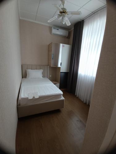 a bedroom with a bed and a ceiling fan at MIMFRI guest house,hotel in Tashkent