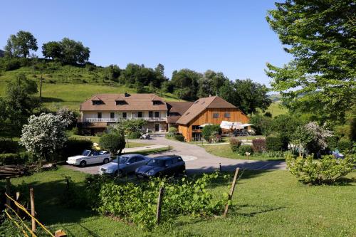 a house on a hill with cars parked in a yard at Maison d'hôtes & SPA La Scierie in Salins-les-Bains