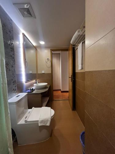 a bathroom with a toilet and a sink and a mirror at Royal Raj Hotel in Rājshāhi