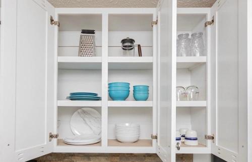 a white cabinet filled with dishes and bowls at Seaside Haven in Myrtle Beach