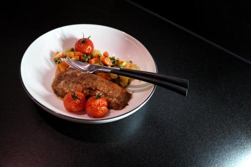 a plate of food with meat and vegetables on a table at Maison d'hôtes & SPA La Scierie in Salins-les-Bains