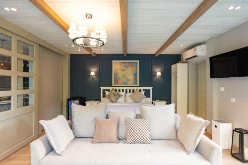 a living room with a white couch with pillows at The Lai Tiny House - Villa at Mae Kampong in Chiang Mai
