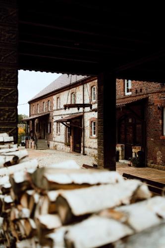 an old brick building with a pile of wood at Na Uboczu in Gryfów Śląski
