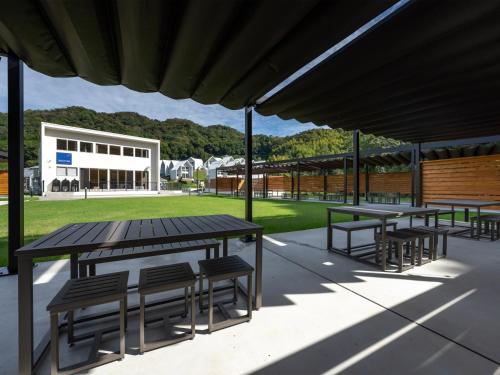 a group of tables and chairs under a building at Kanatanosato in Kawanabe