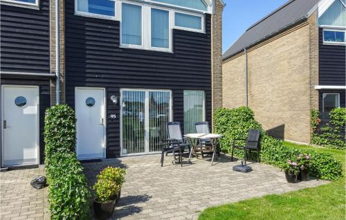a patio with chairs and a table in front of a building at Holiday Home Næsvej Xi in Assens