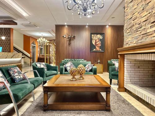 a waiting room with green chairs and a fireplace at Hotel Glamour da Serra in Gramado