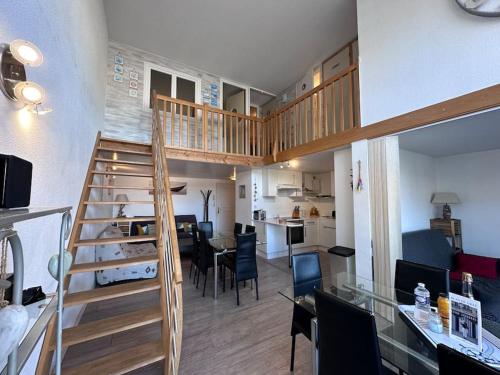 un salon avec un escalier et une salle à manger dans l'établissement Les Lofts vue Port Guillaume, à Dives-sur-Mer