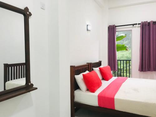 a bedroom with a bed with red pillows and a window at River Line -Ella in Ella