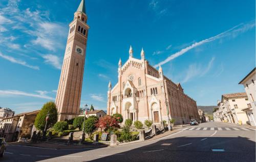 a church with a clock tower in front of a building at Gorgeous Home In Pieve Di Soligo in Pieve di Soligo