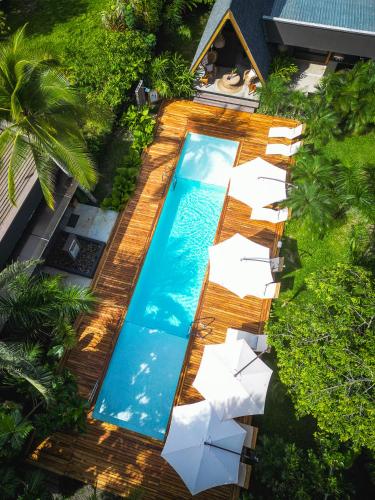 an overhead view of a swimming pool with chairs and umbrellas at Namu Garden Hotel & Spa - Adults Only in Puerto Viejo