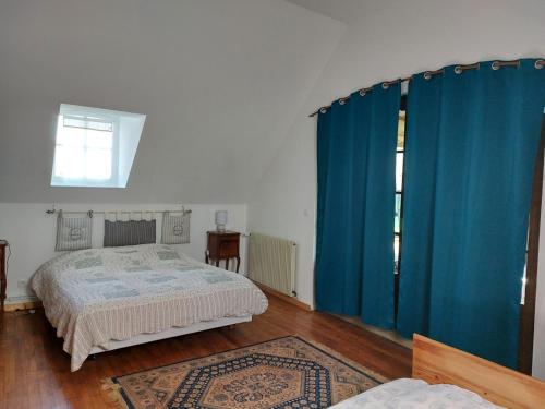 - une chambre avec des rideaux bleus et un lit avec un tapis dans l'établissement moulin des Gondrillers Jusqu'à 30 personnes, à Saint-Martin-dʼÉcublei
