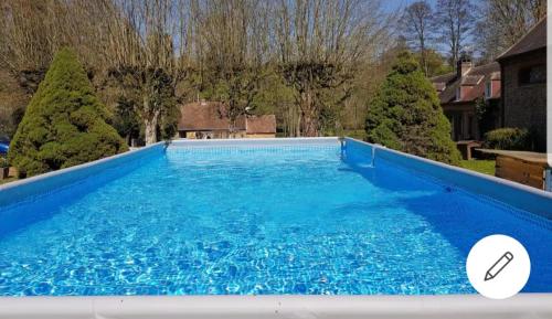 une grande piscine bleue dans une cour dans l'établissement moulin des Gondrillers Jusqu'à 30 personnes, à Saint-Martin-dʼÉcublei
